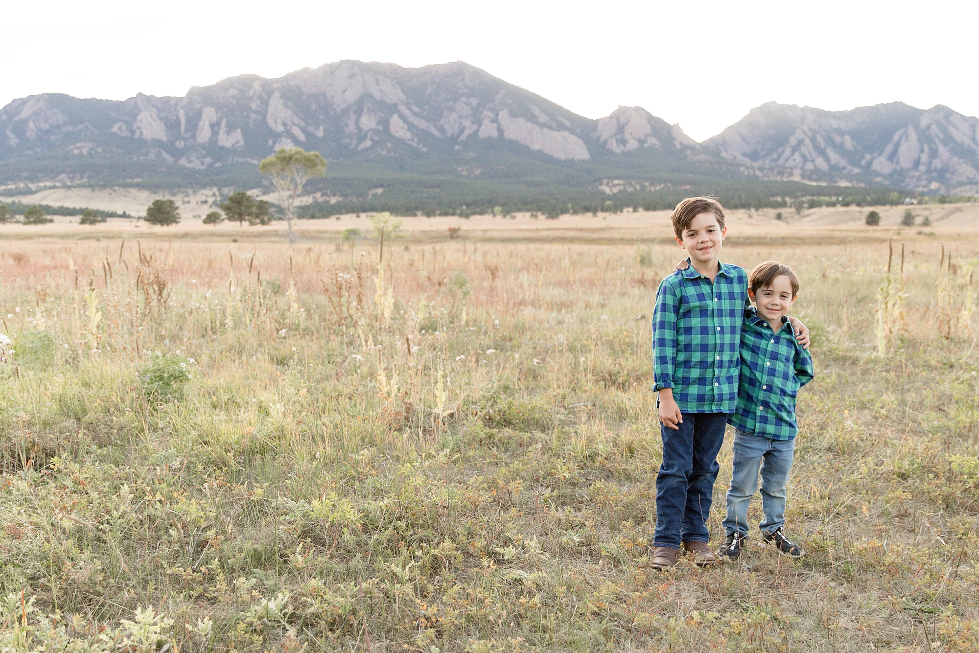 brothers hug in field at South Boulder Creek Trailhead