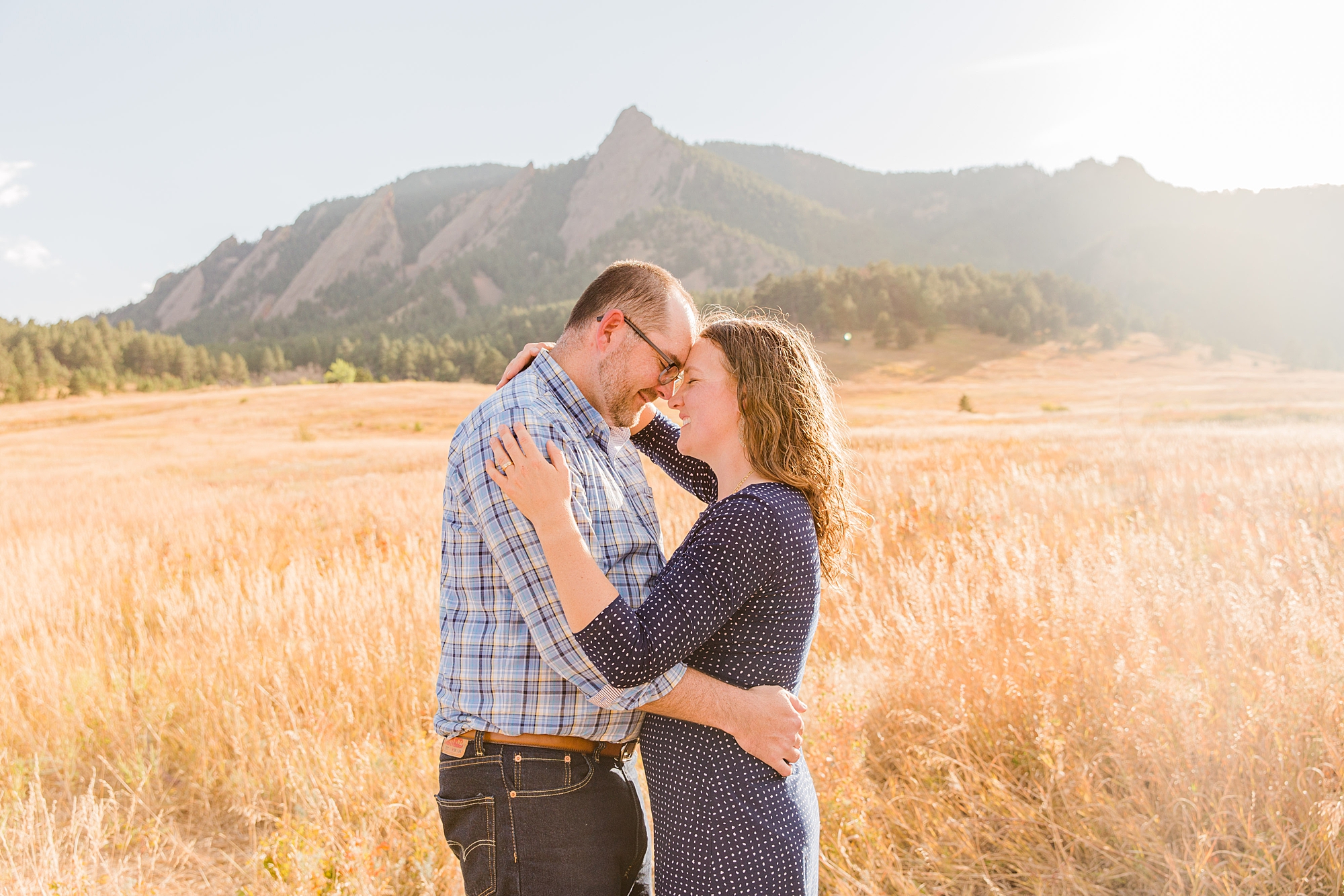 couple lean in together with the gorgeous mountains in the backdrop