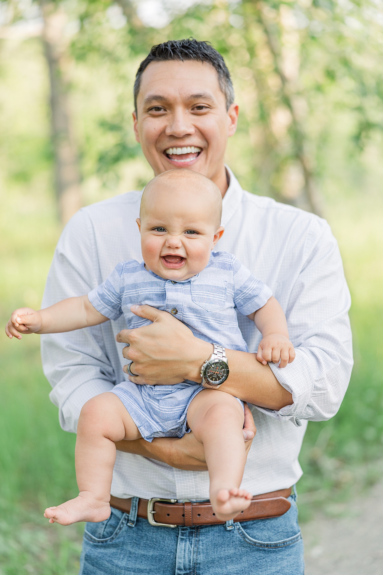 dad hold his baby boy in arms during Boulder CO Spring Family Session at South Mesa Trailhead