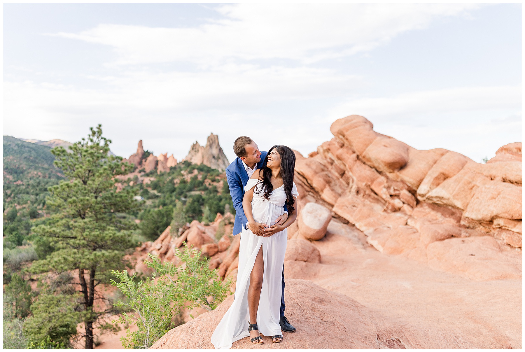 Garden of the Gods couple gazing into eyes while holding belly