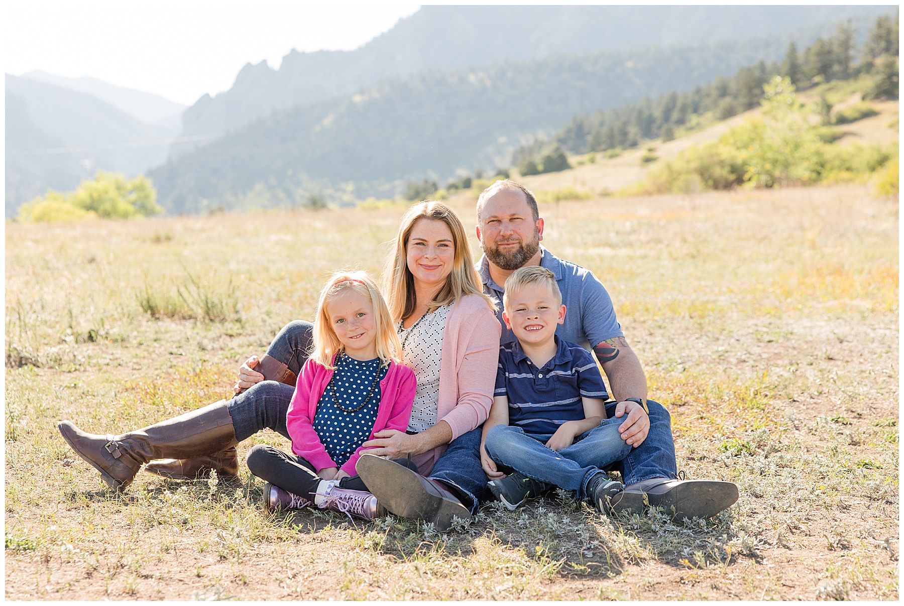 ideal setting for fall family portraits as family of four poses in front of the flatirons in Boulder, CO