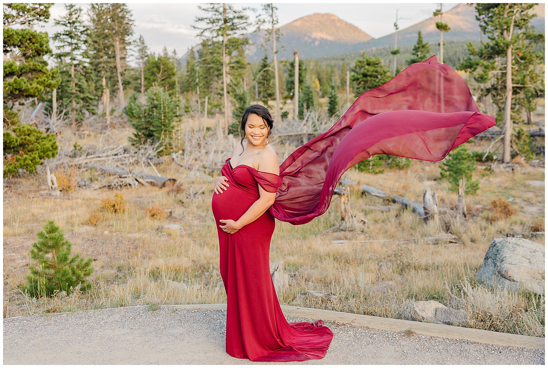 radiant mother-to-be with red dress flying in the wind