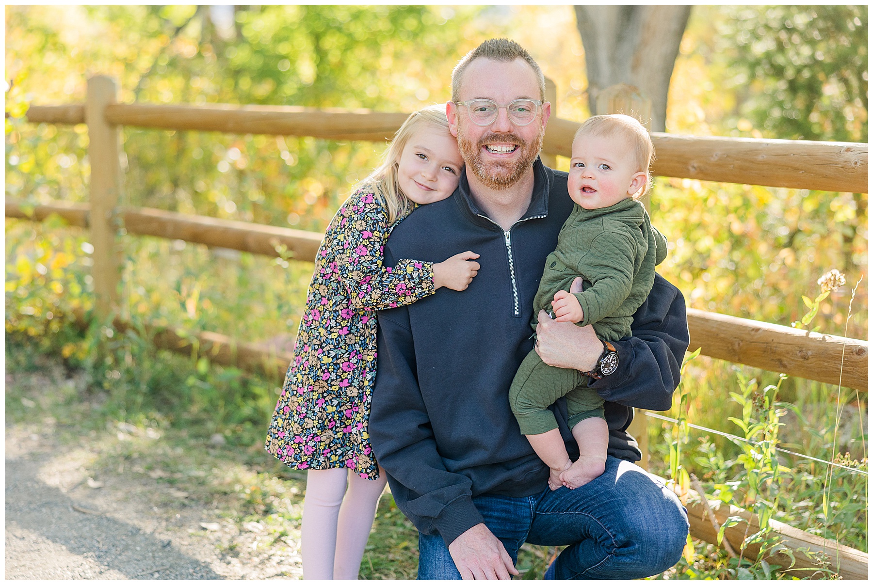 dad squats down with kids during fall mini sessions in Boulder