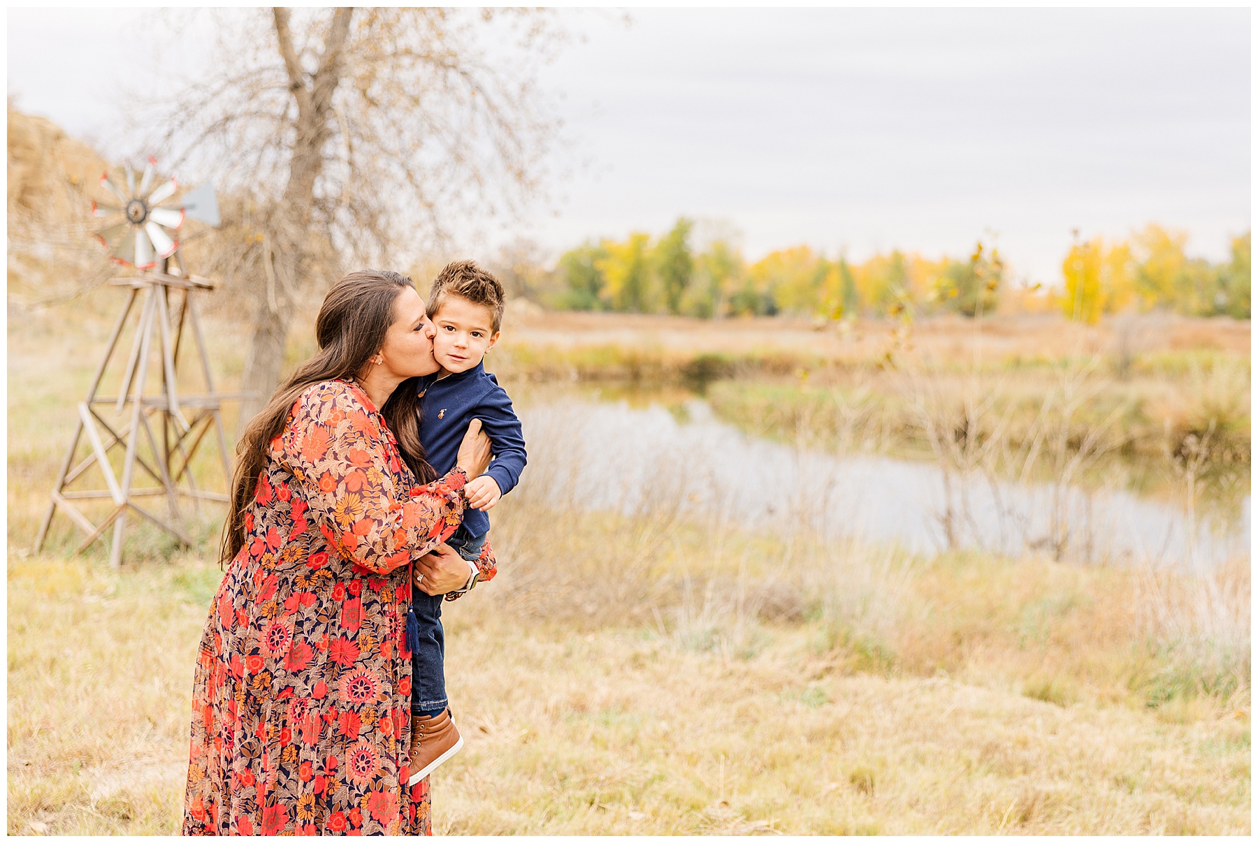 beautiful mom kisses her son at Sandstone Ranch in the fall