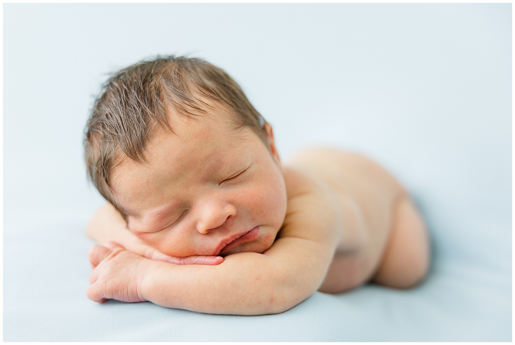 newborn baby asleep on blue background