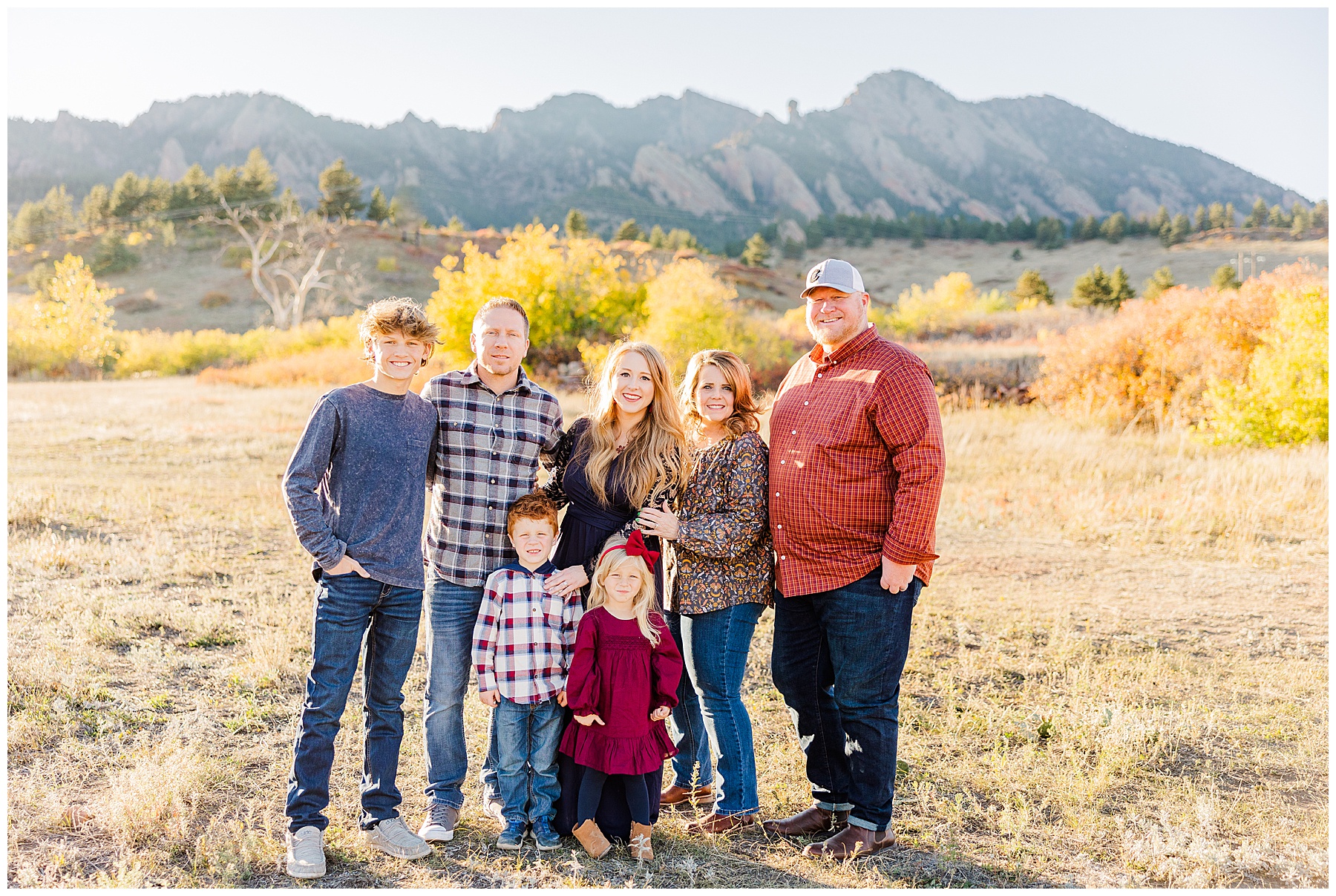 Family takes fall mini session picture with flatirons in the background