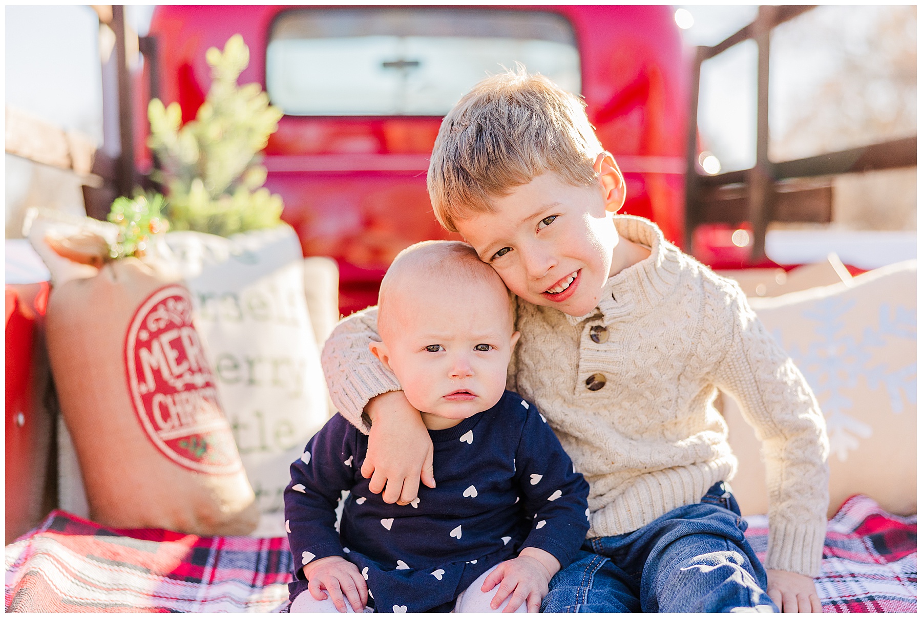 older brother has arm around his younger sibling in Christmas mini sessions in Louisville, Colorado 