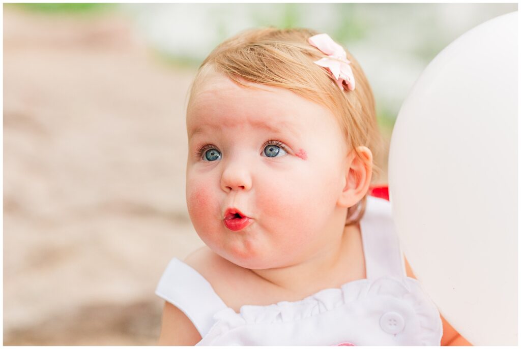 Baby girl puckers her lips for a close up during a family session by Catherine Chamberlain Photography