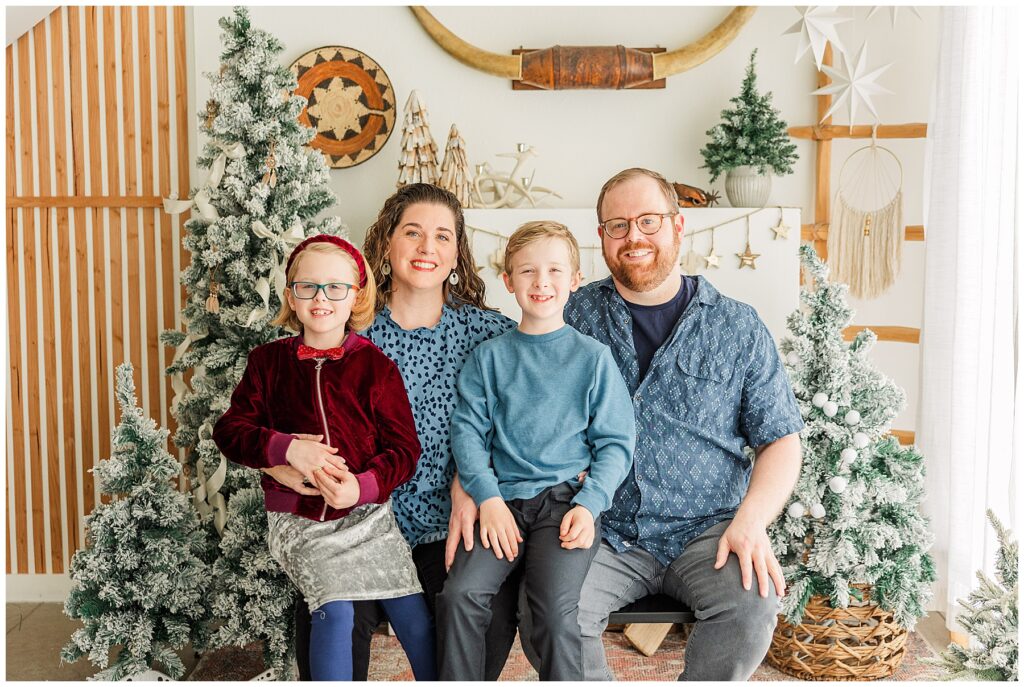 Family of four pose for cozy southwest Christmas minis at Sugarhill Studio in Longmont, CO