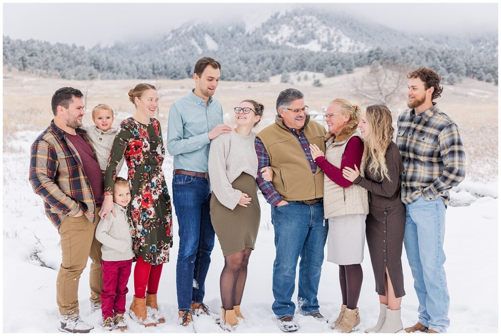 Extended family all look at each other for winter pictures in Colorado