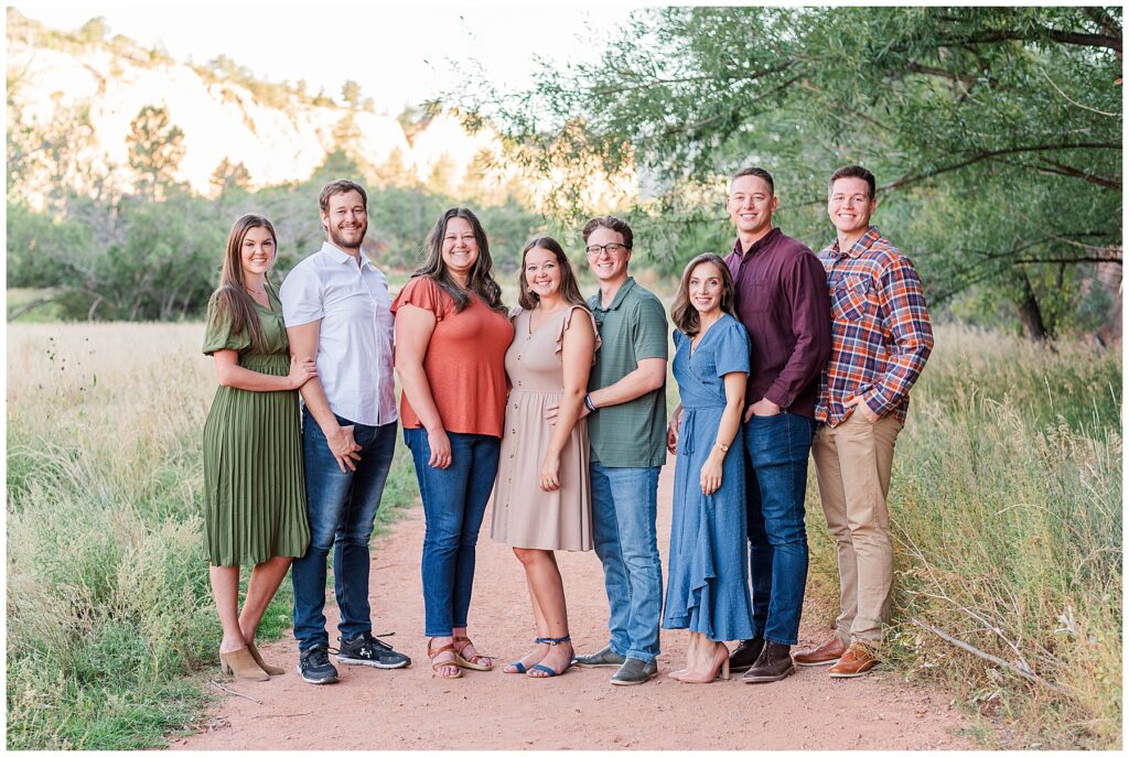 Five adult children and their spouses pose on a pathway during Anderson Extended Family Session | Red Rocks Open Space, Colorado Springs, CO