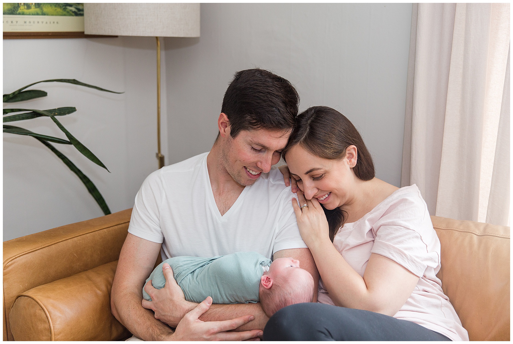 parents smile while looking at their baby