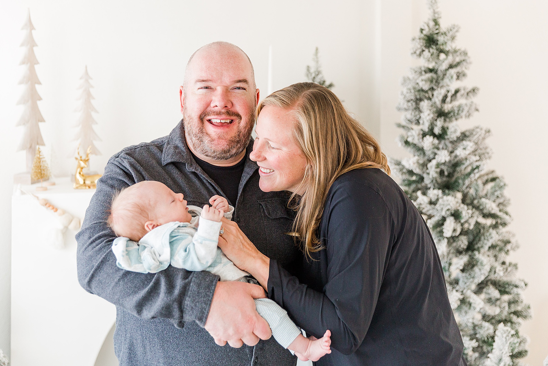 mom and dad hold their baby boy during Christmas mini