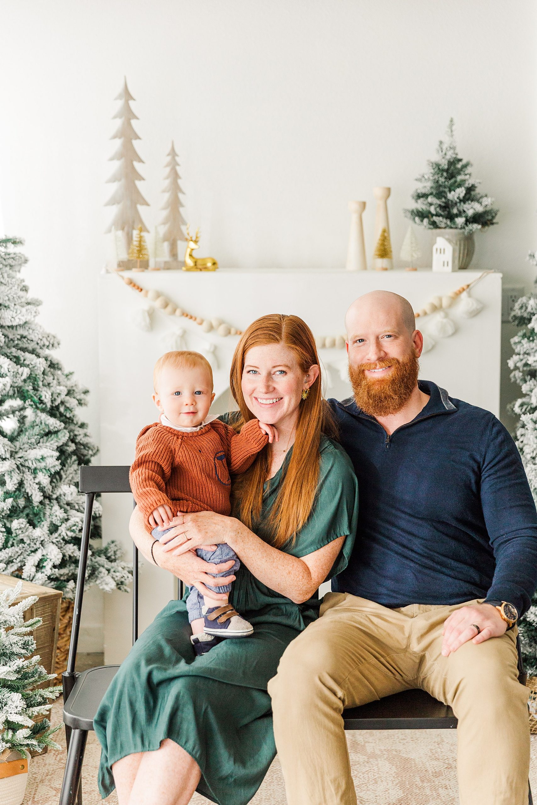 mom and dad hold their baby for Christmas photos