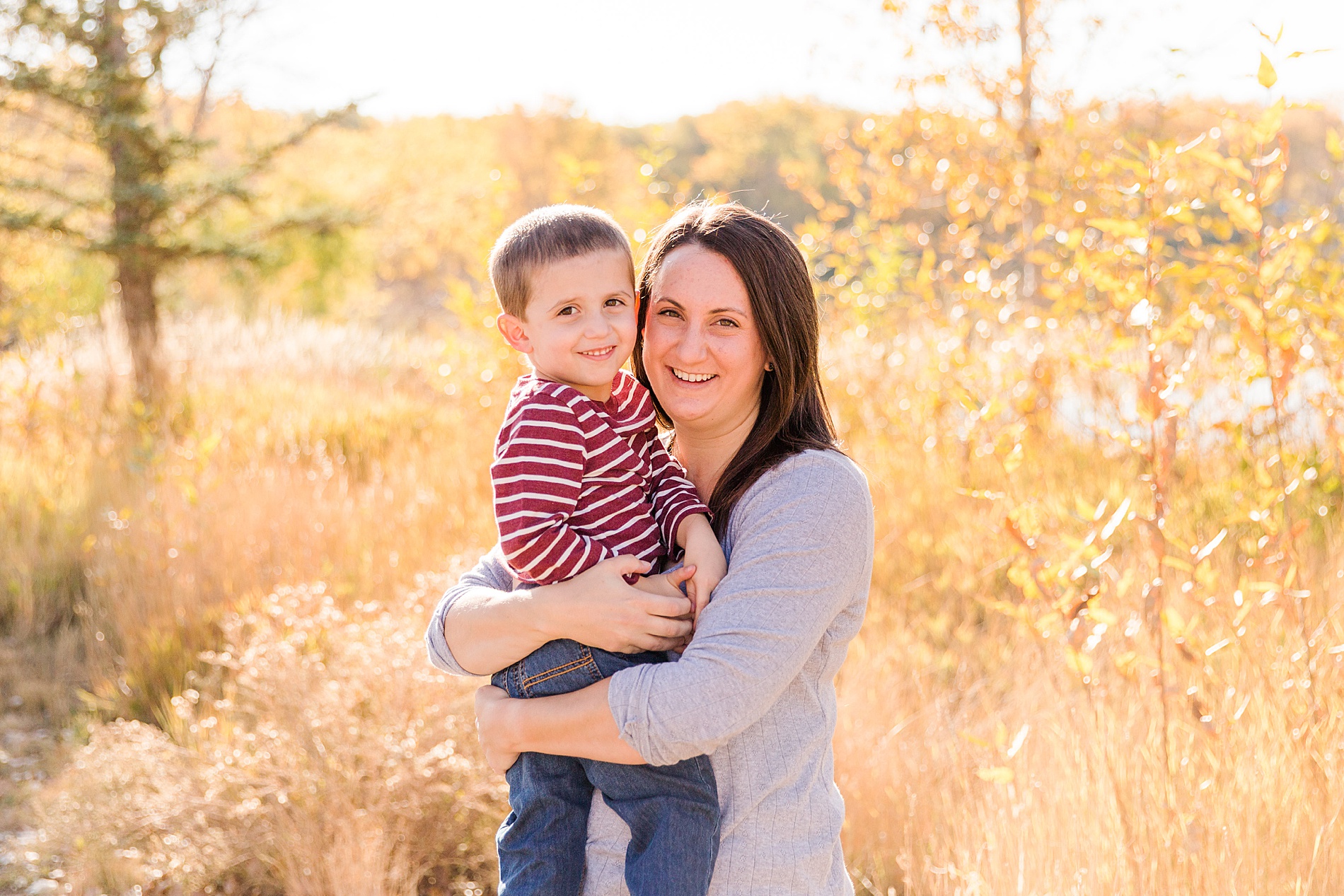 mom holds her son during fall mini session at Golden Ponds in CO