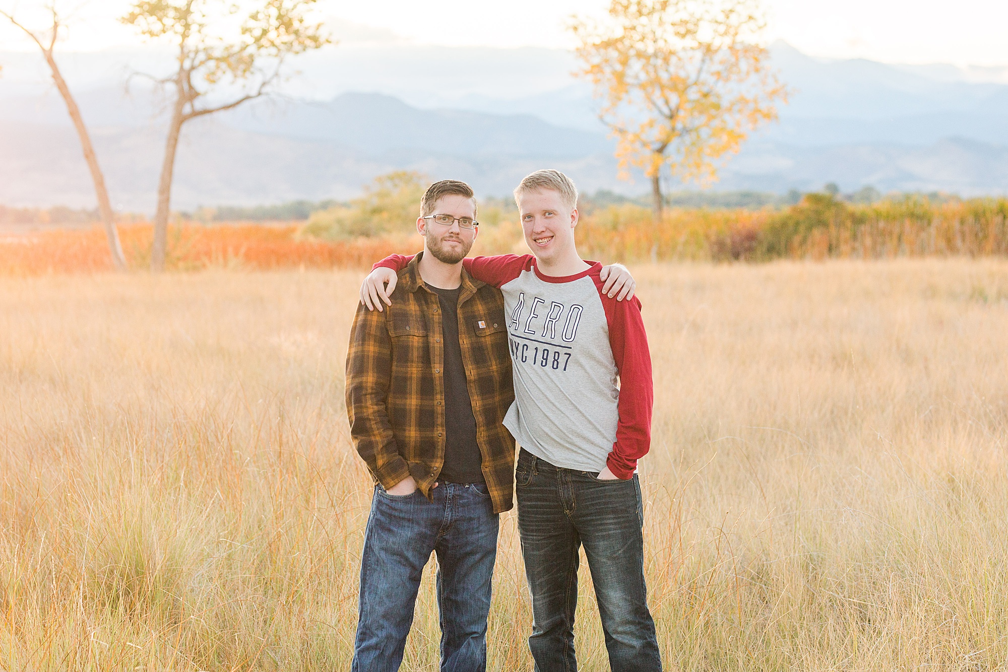 brothers hug in a field of grass