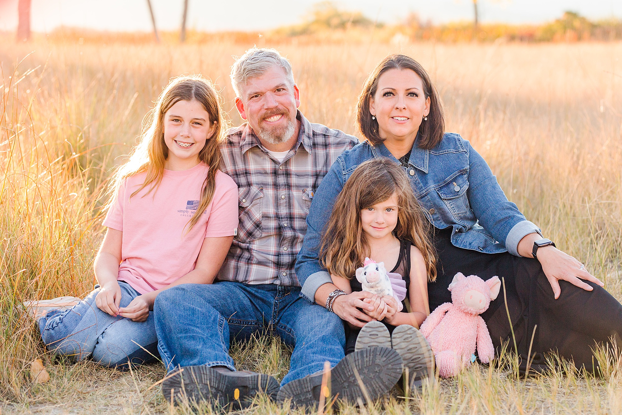 parents sit with their two girls during fall family session
