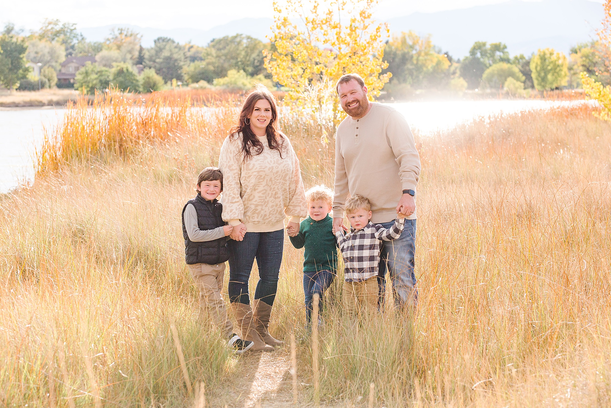family stands in tall grass near McIntosh Lake in Longmont CO