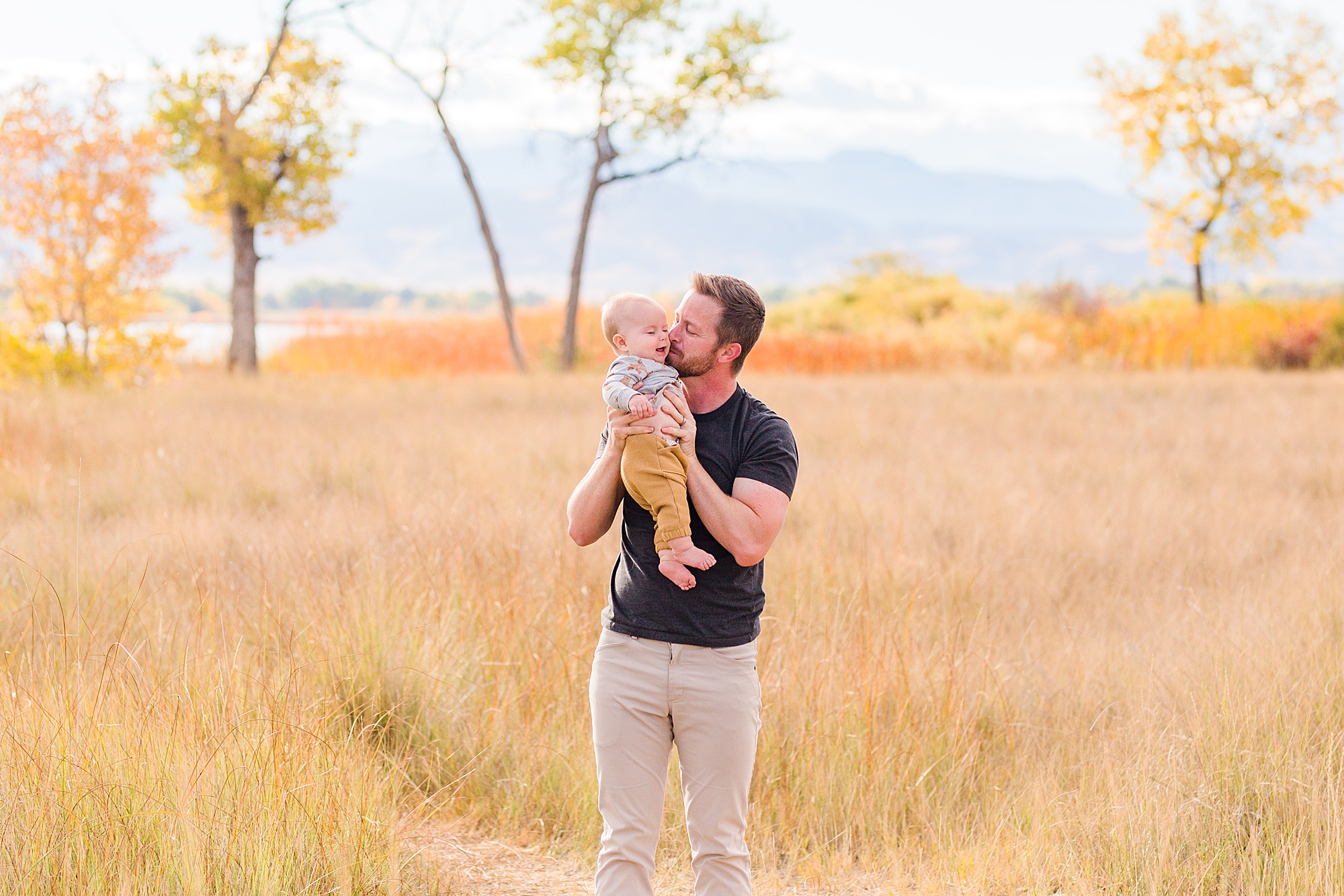 dad holds his son during Fall Family Mini Sessions in Longmont Colorado