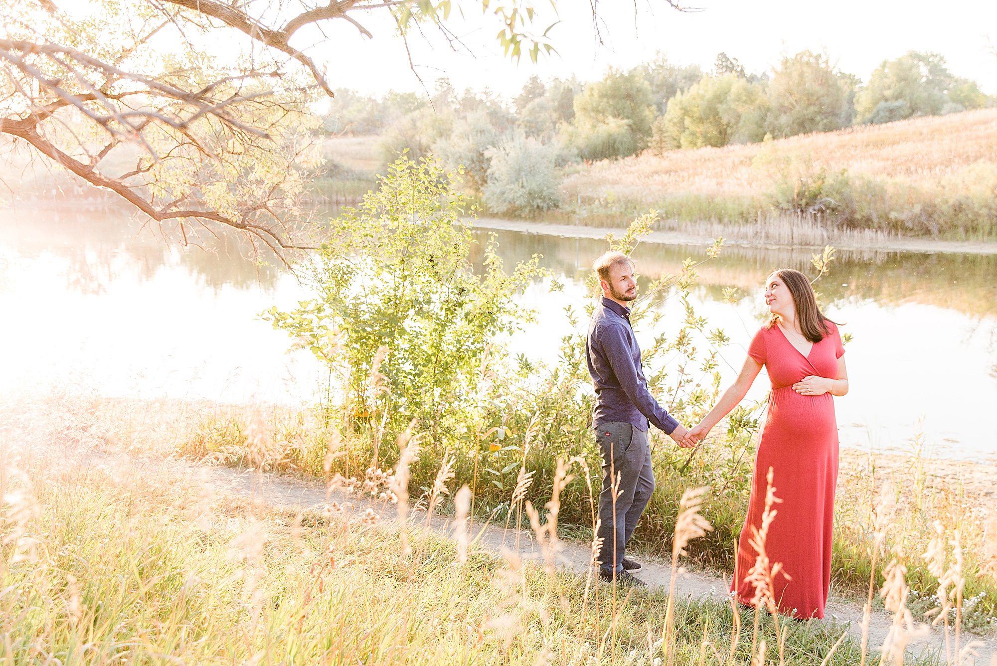 couple holds hands by the lake at Majestic View Park in Arvada, Colorado
