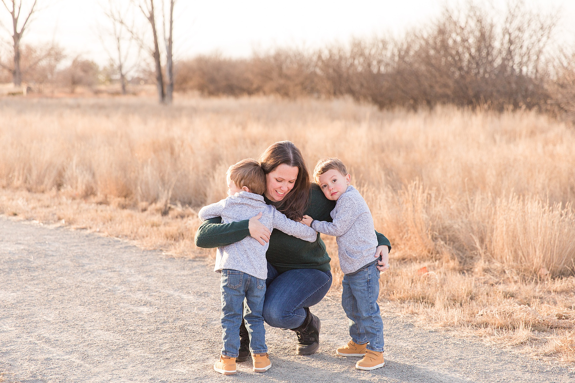 mom receives hugs from her twin boys