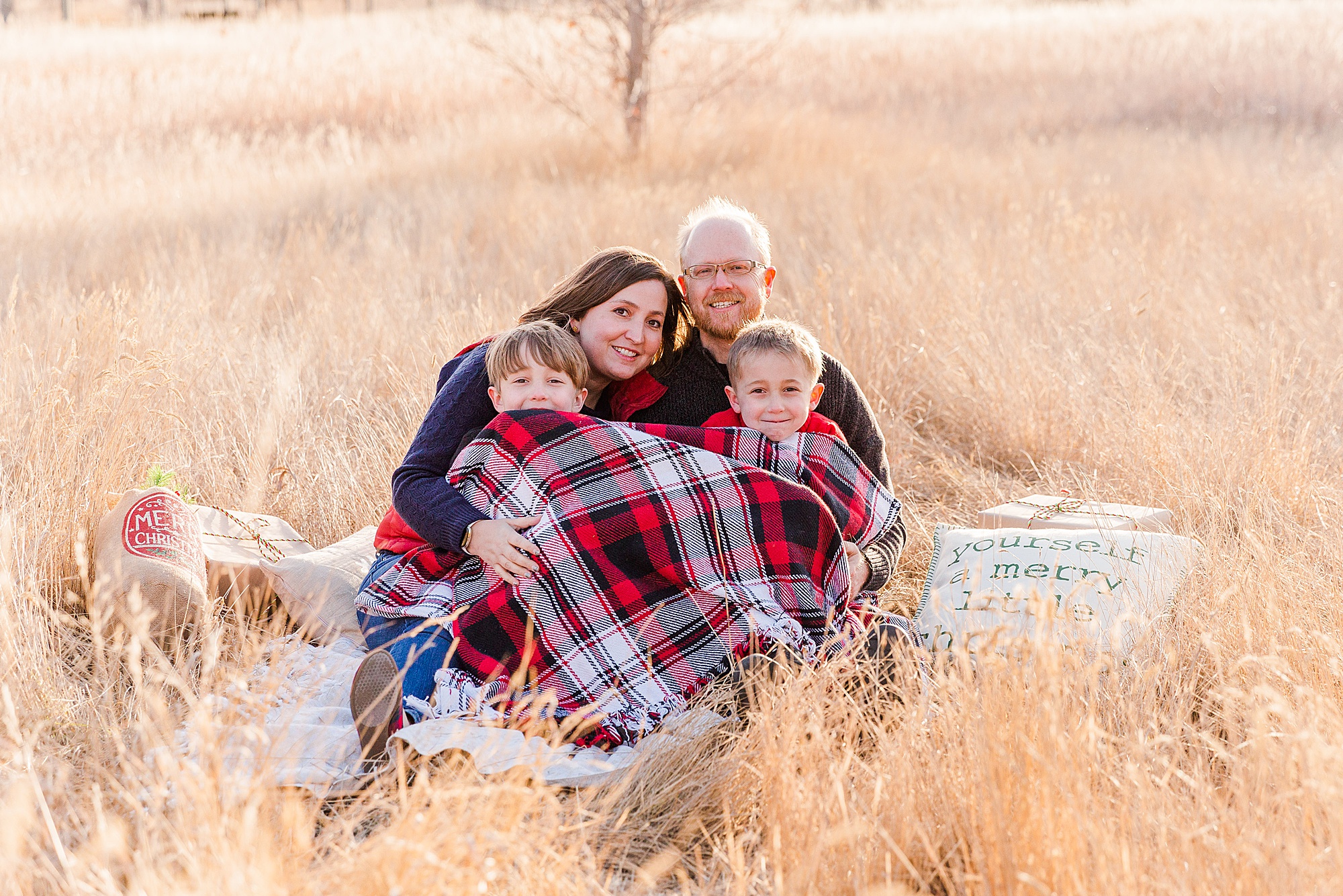 family cuddles under the blanket during chilly mini session in CO