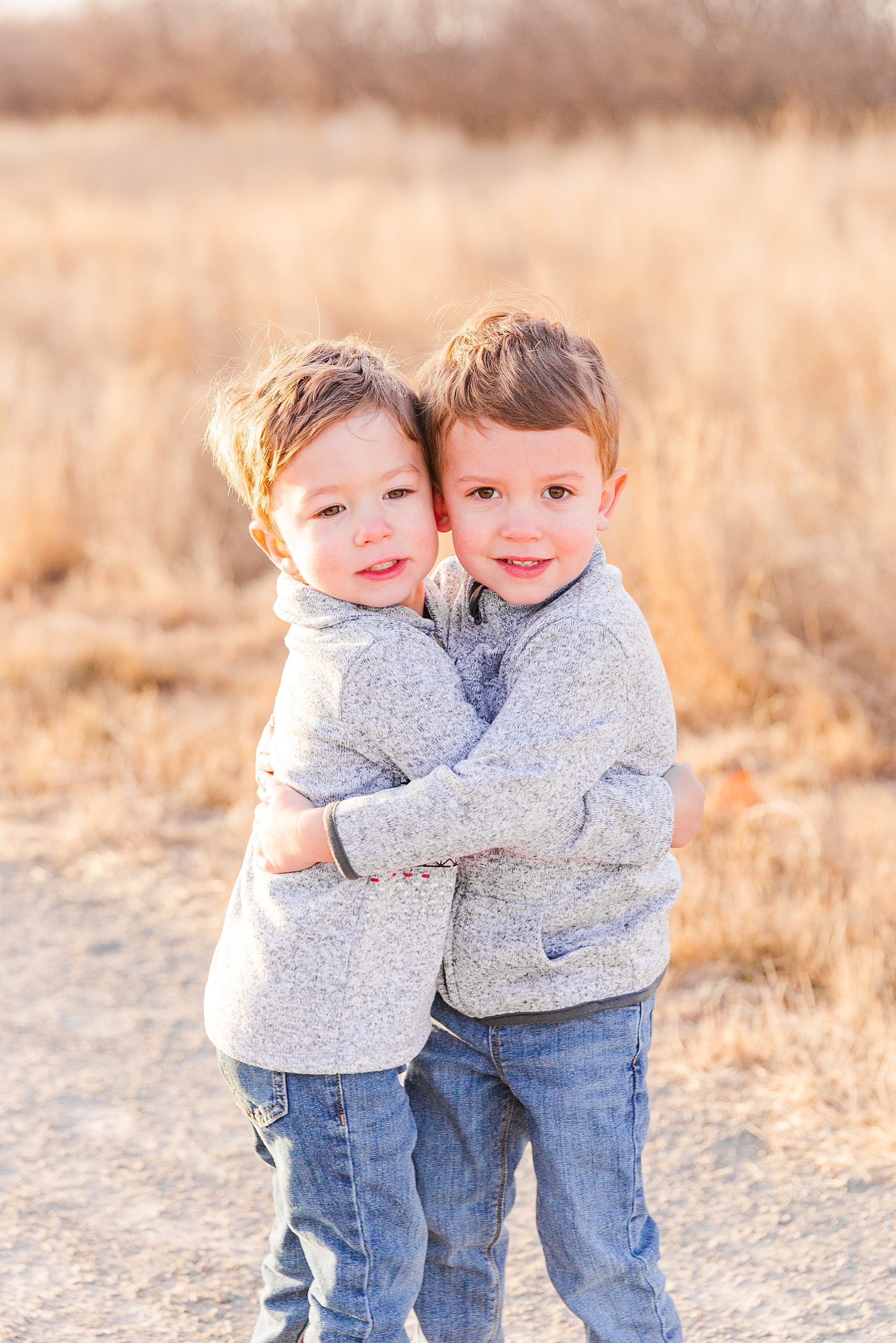 twin brothers hug during Boulder Twins Club Mini Sessions at Jim Hamm Nature Area in Longmont, COBoulder Twins Club Mini Sessions at Jim Hamm Nature Area in Longmont, CO