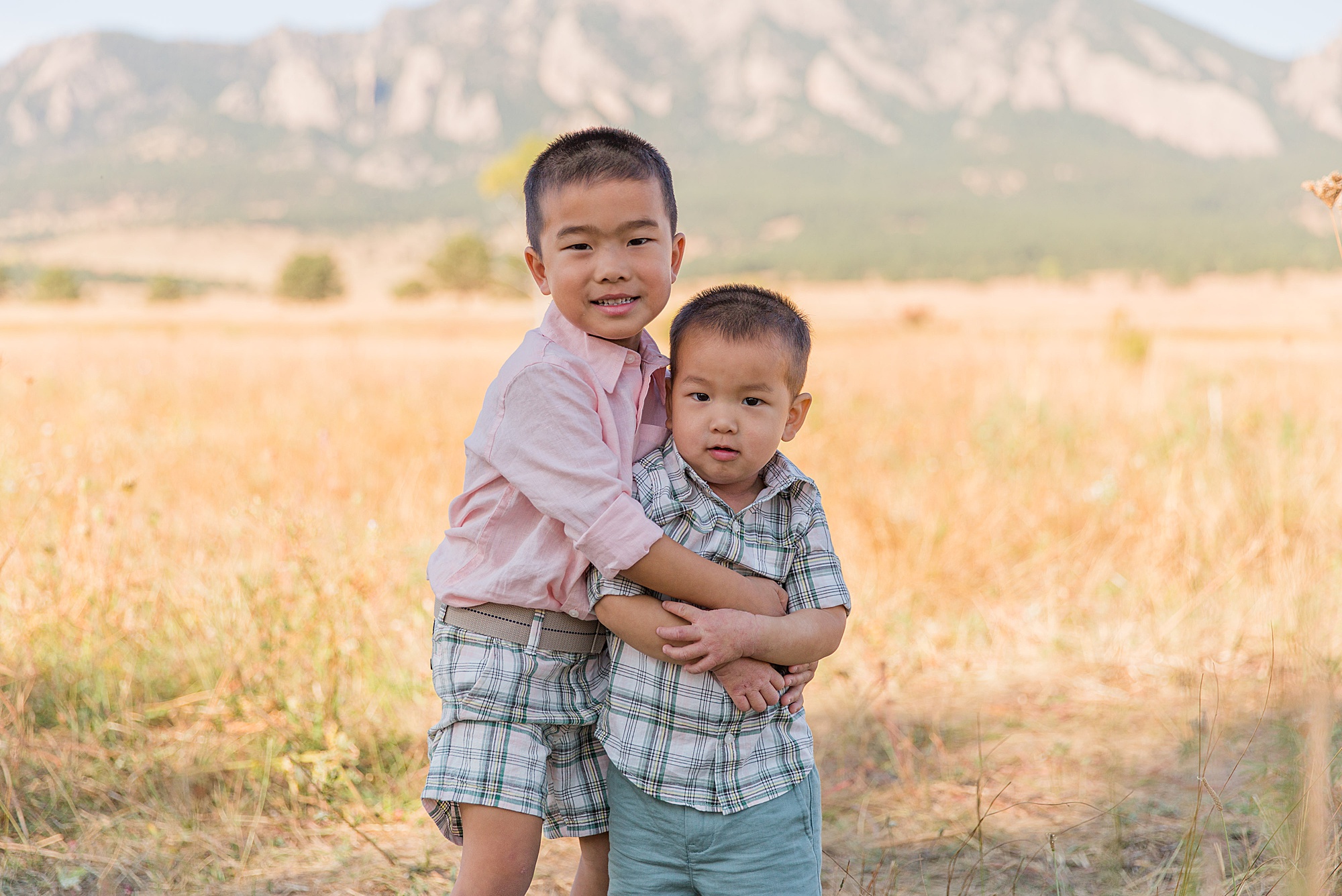 young brothers hug with the beautiful mountains in the background