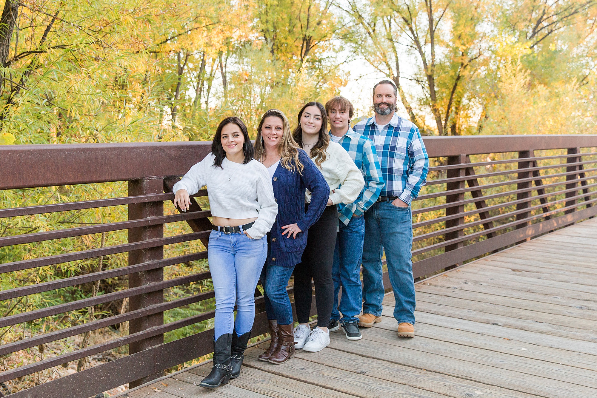 family of five stand on wooden bridge at Golden Ponds in Longmont CO