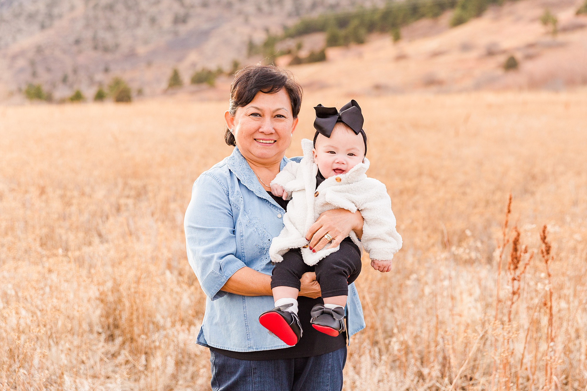 grandma holds baby granddaughter during South Mesa Trailhead Extended Family Session
