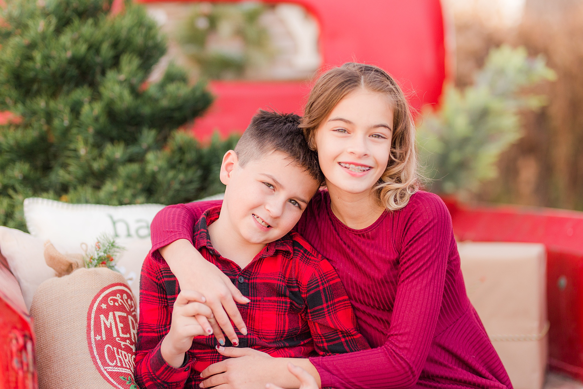 brother and sister hug during Christmas Red Truck Mini Sessions