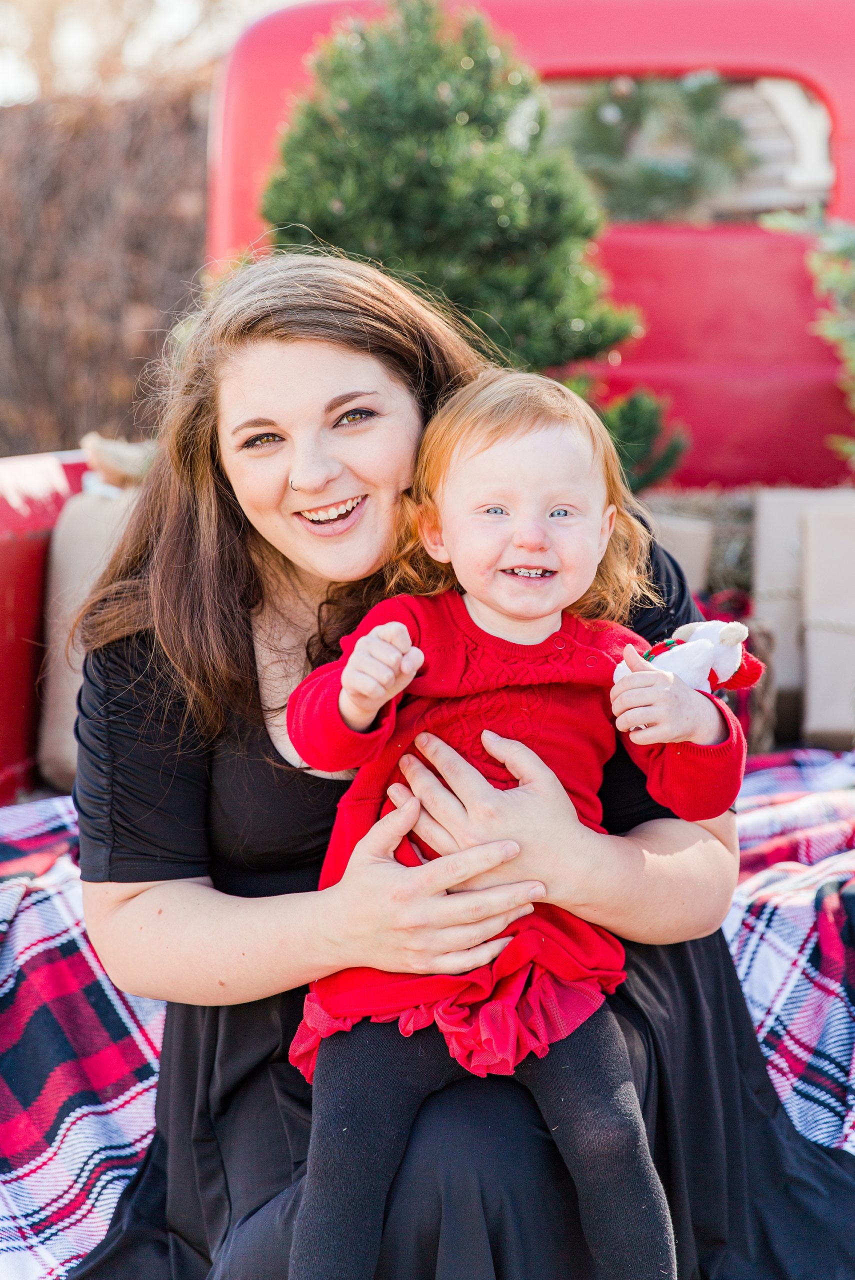 mom holds little girl in red dress