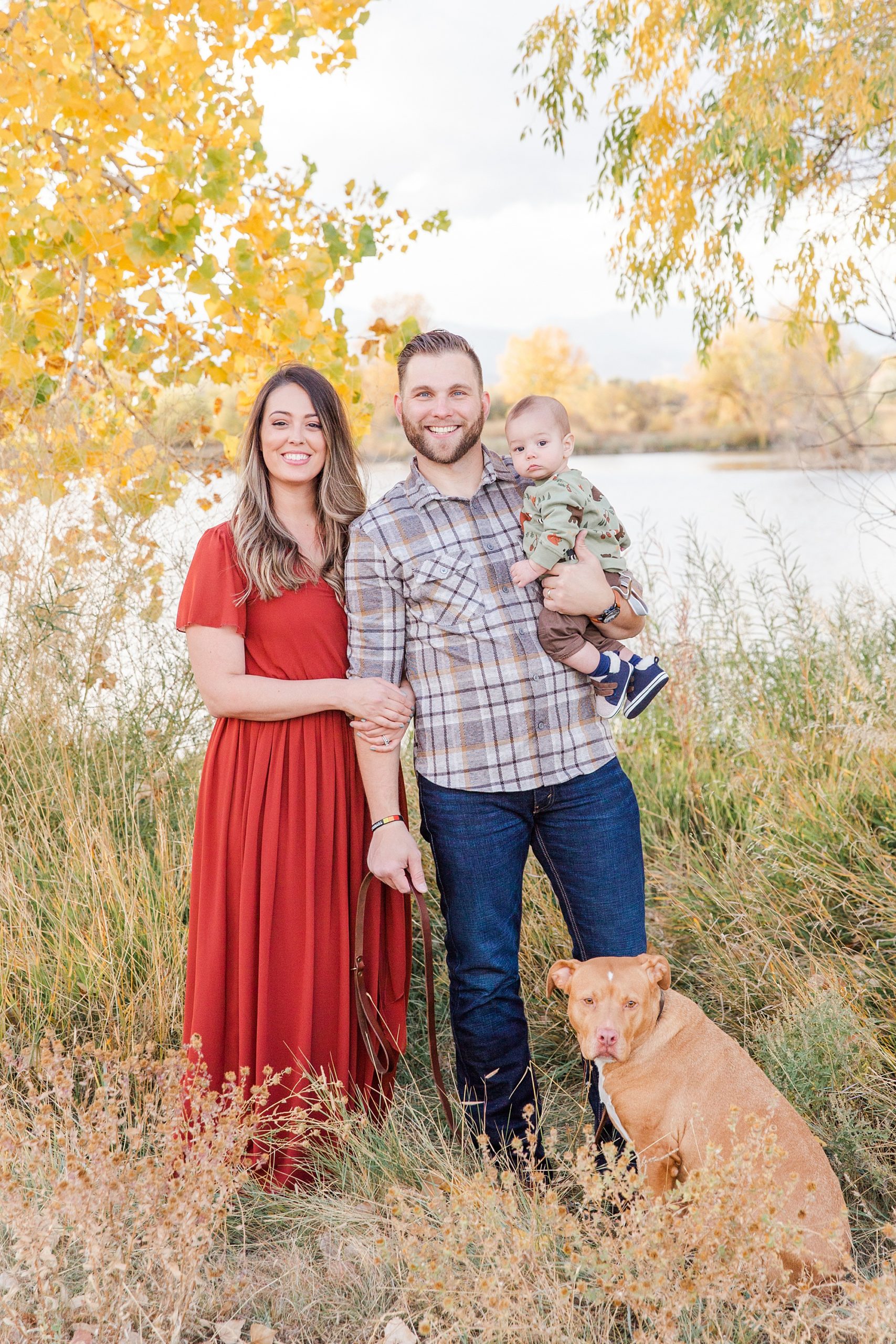 mom and dad hold son with their dog during Golden Ponds Family Portraits