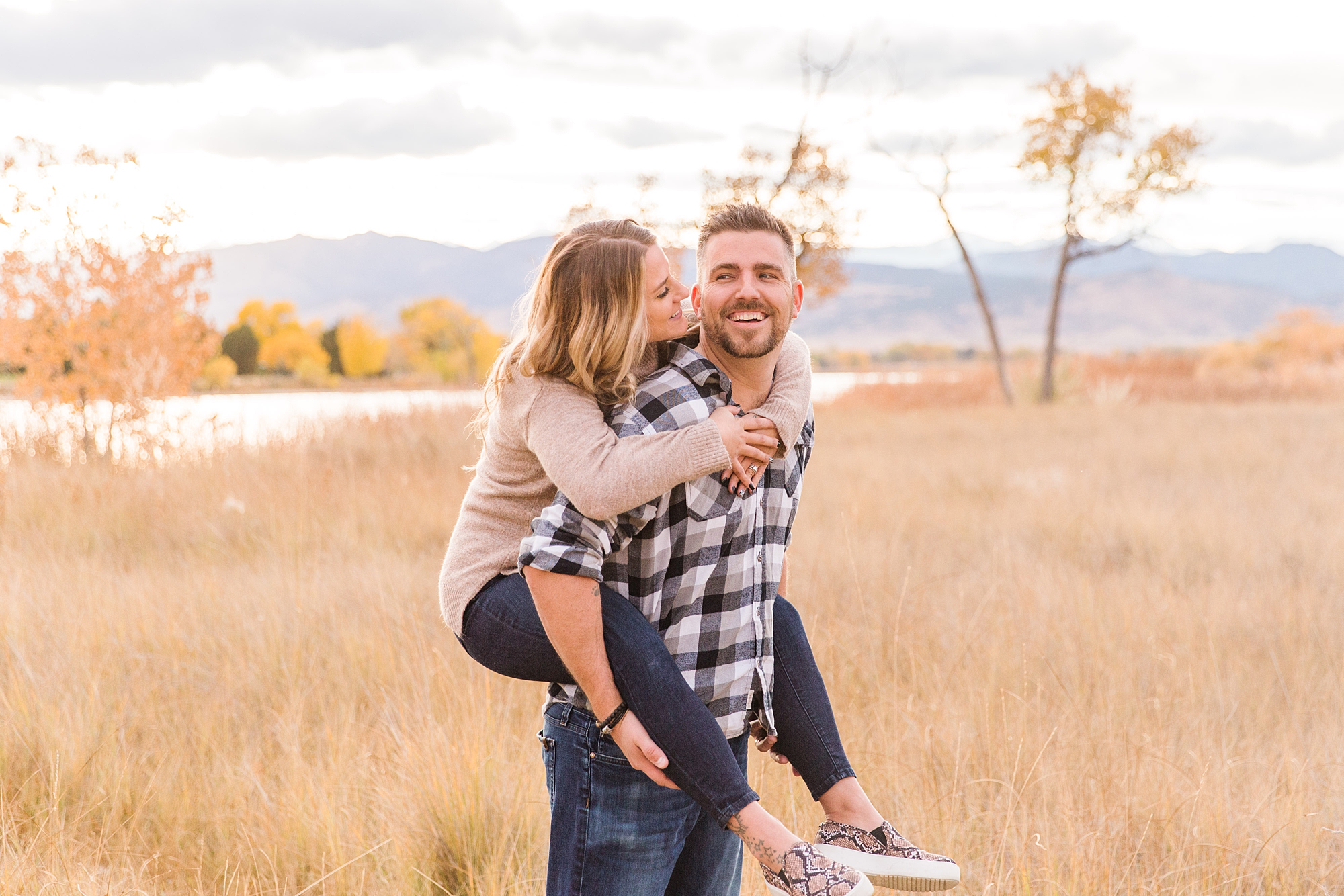 guy carries his wife on his back during family photos