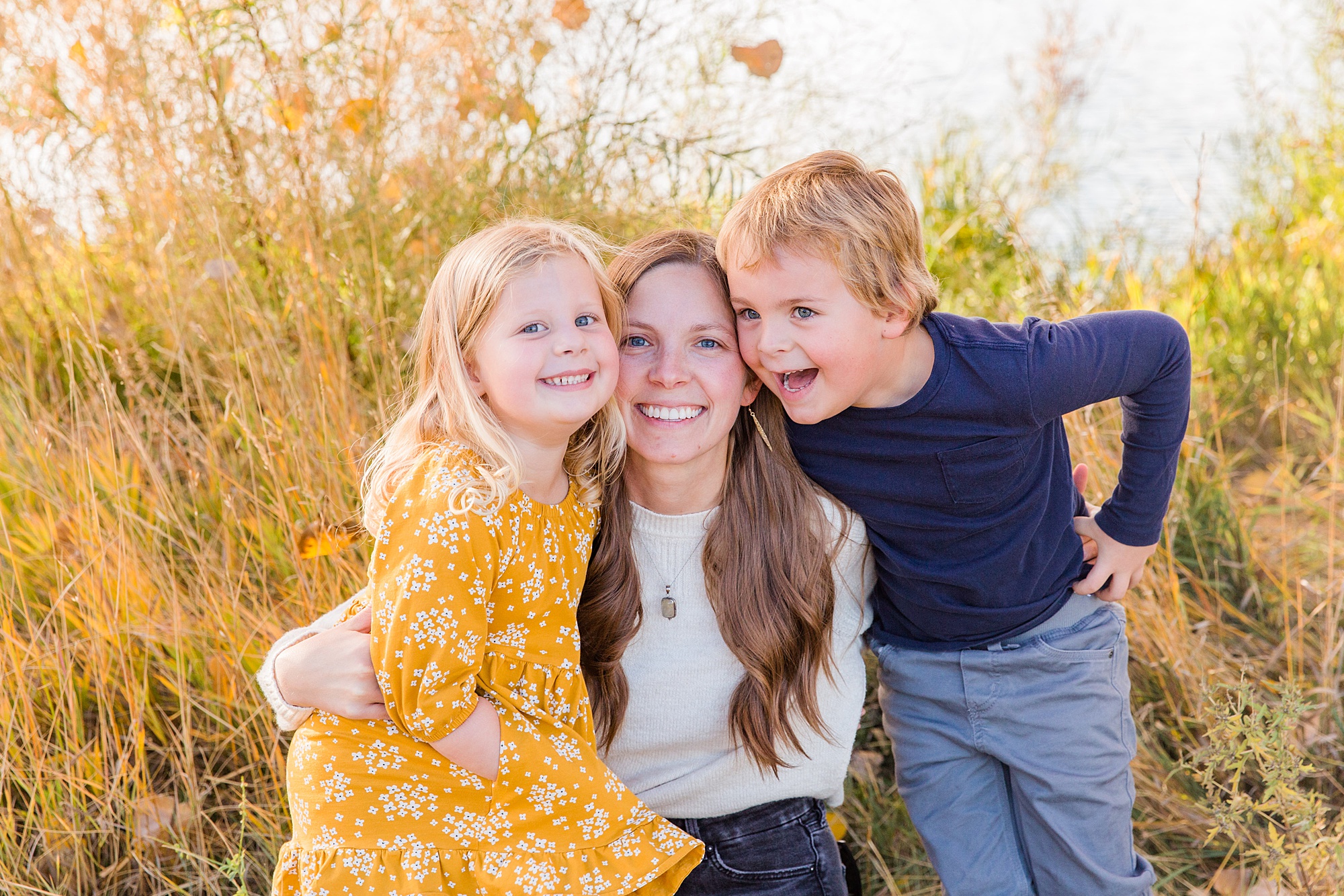 mom hugs her two kids during autumn family session
