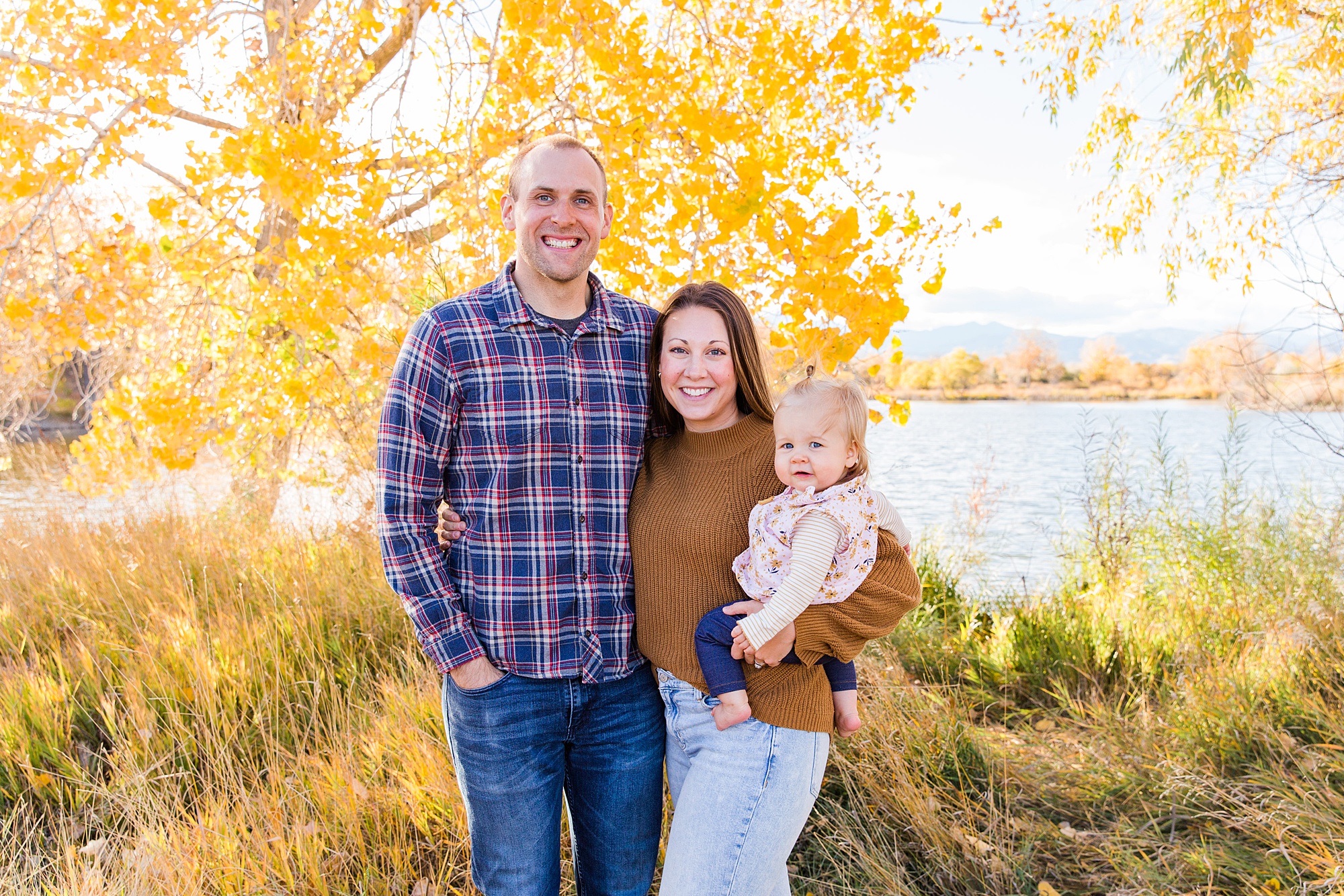 parents hold their baby daughter during fall family photos