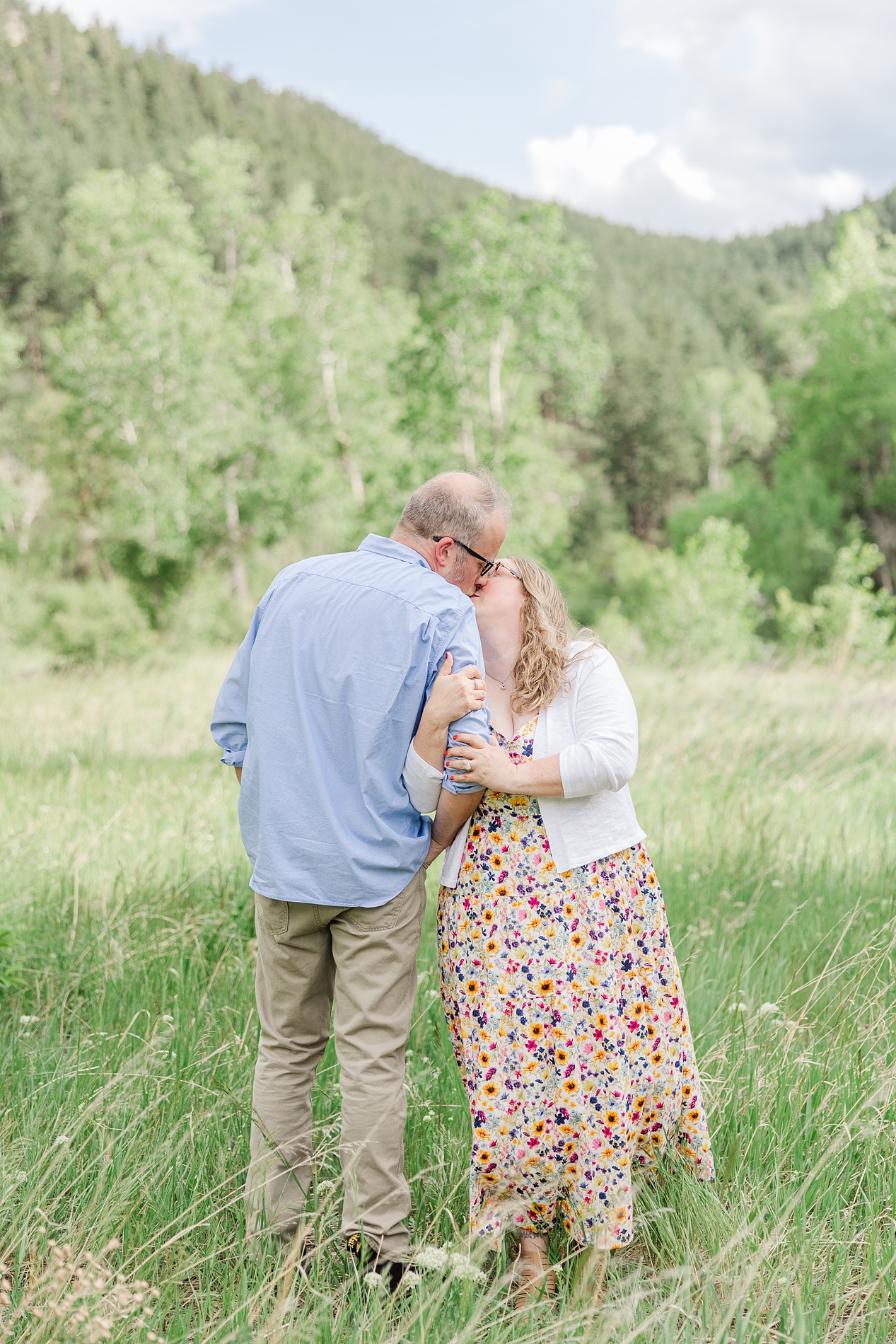 husband and wife kiss during family session at Boulder, CO