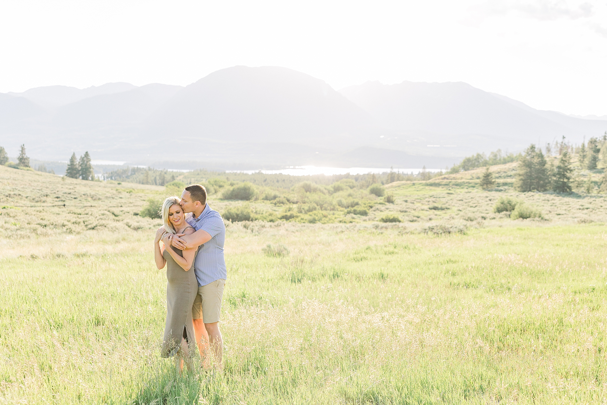 couple in the grass with CO mountains in the background