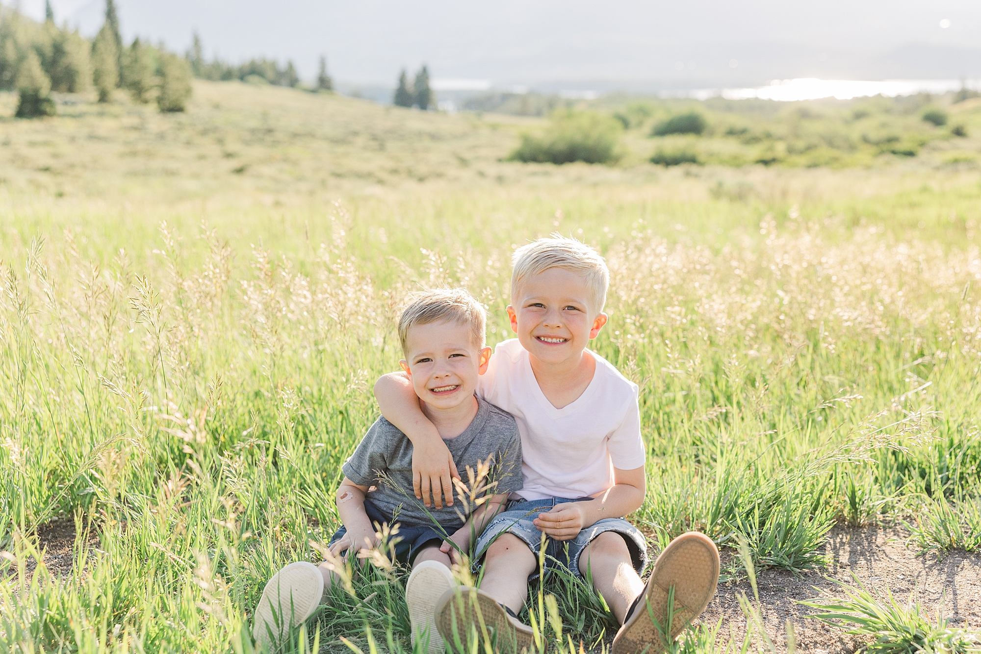 brothers sit together in the grass during Scenic Dillon CO Extended Family Session