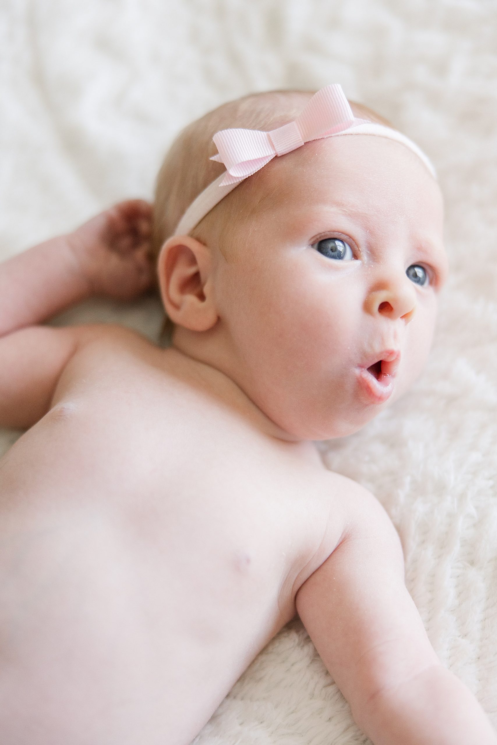 adorable baby girl makes funny faces during In-home Family Newborn Session in Longmont, CO 