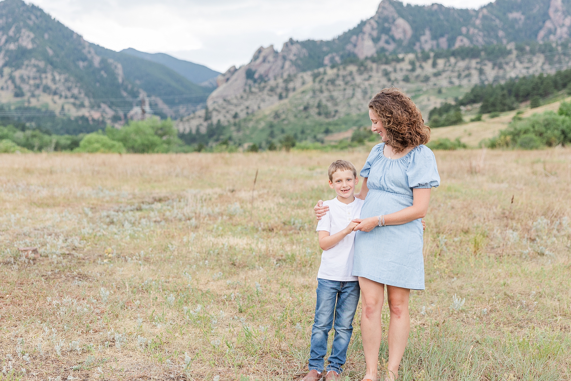 mother and son stand in front of mountains at South Mesa Trailhead