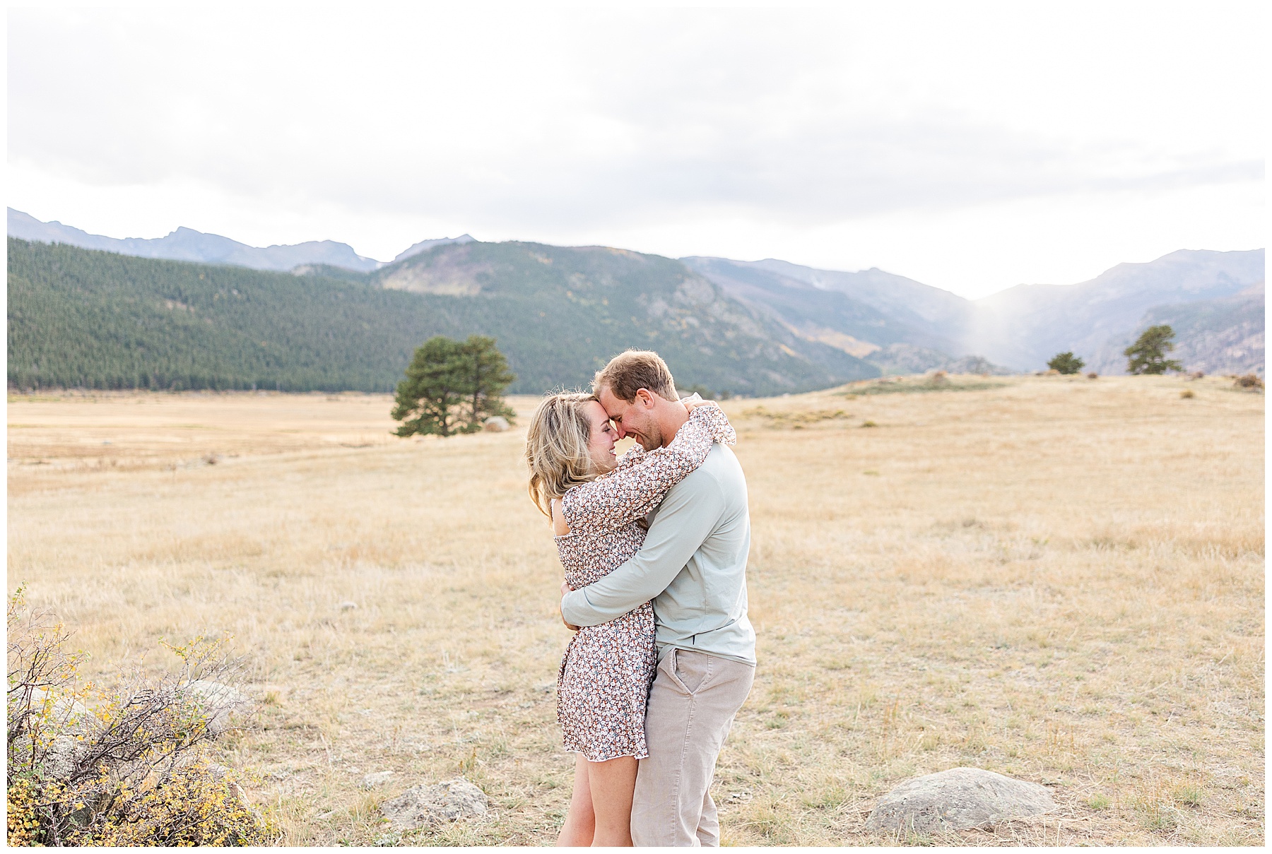 couple standing in the valley of Moraine Park with Rocky Mountains behind them