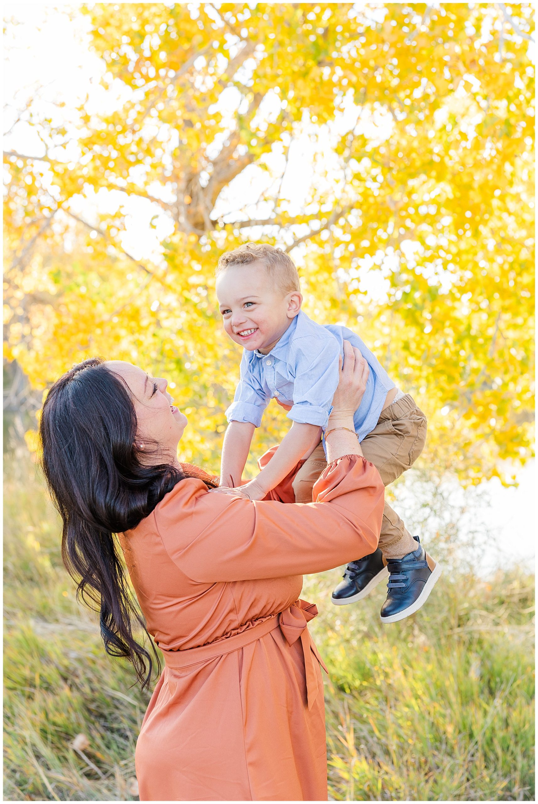 mom holding child in air while child laughs