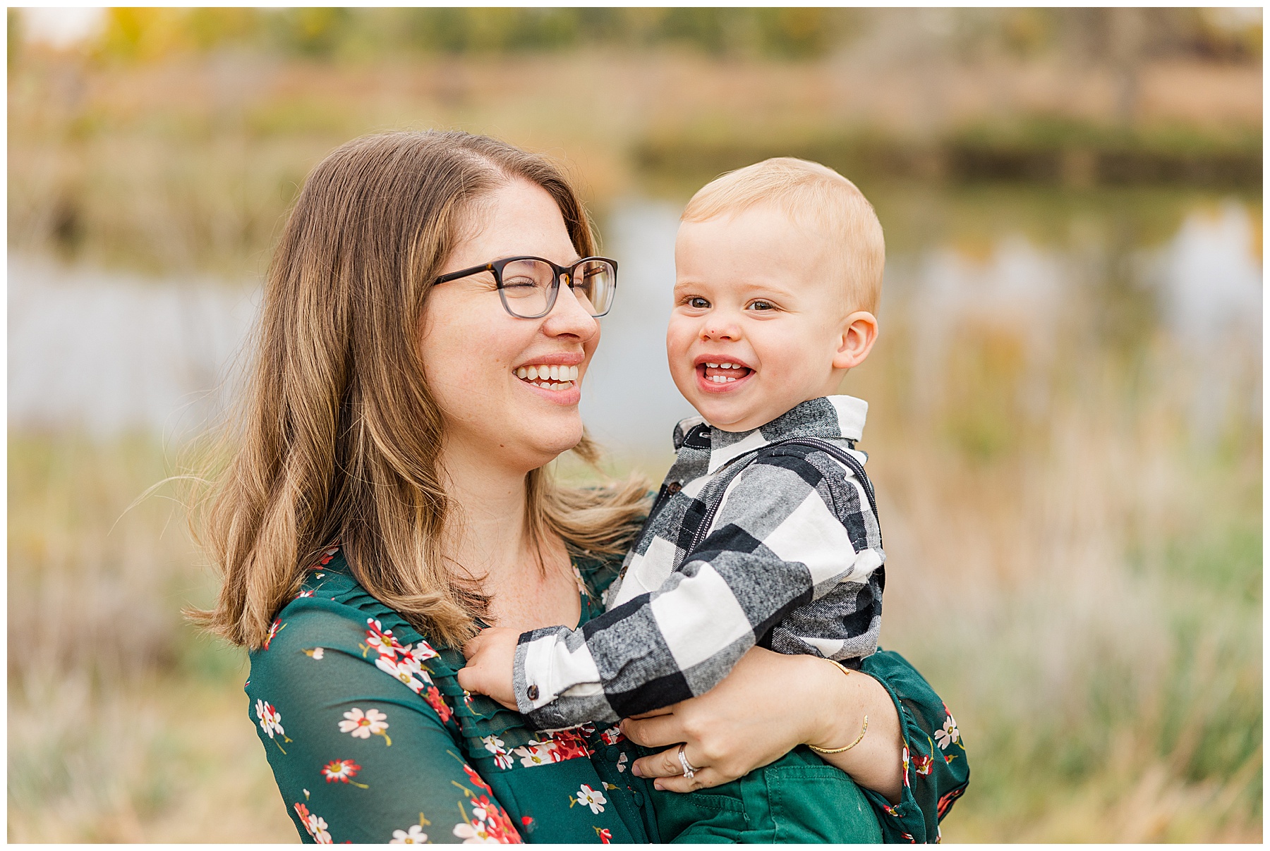 mother looks gleefully at smiling son during fall minis