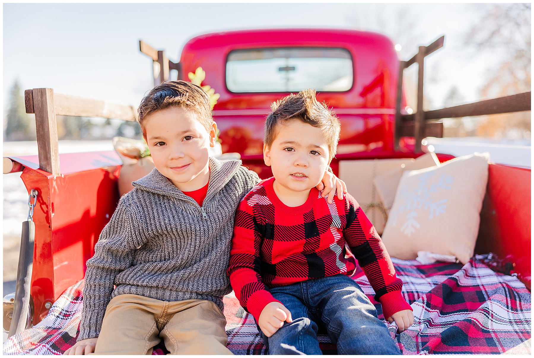 older brother puts his arm around his younger brother in family session