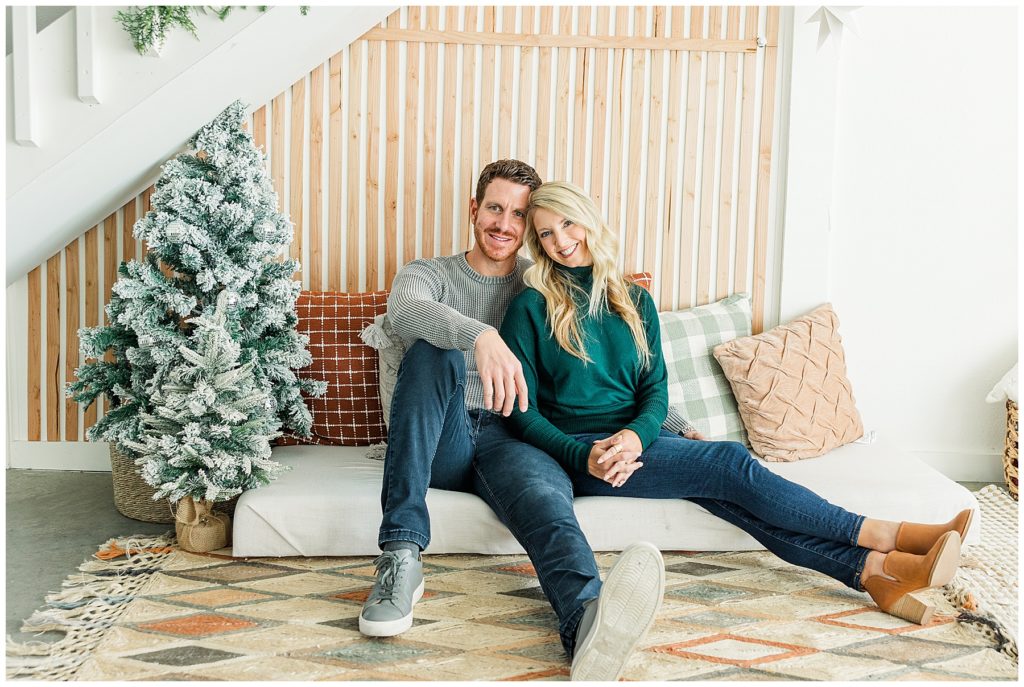 couple snuggle up together during studio Christmas minis