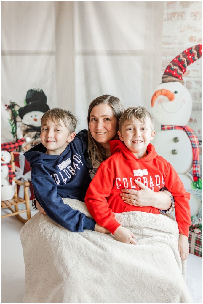 mom and twin boys have their photo taken at St Aidan's Episcopal Church, Boulder, CO for Twins Club Winter Minis