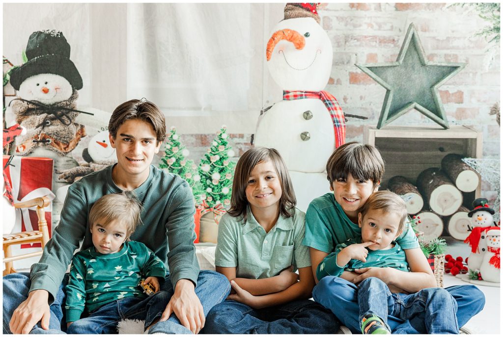 siblings sitting on the floor of a snowman set for non-profit organization 