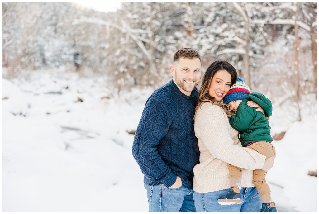Family snuggles and looks at camera during winter photo session at Buckingham Park