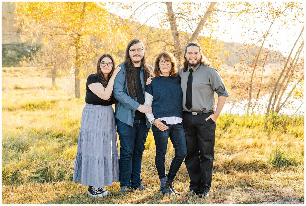 mother stands with her three kids and pose for a fall mini session in Longmont